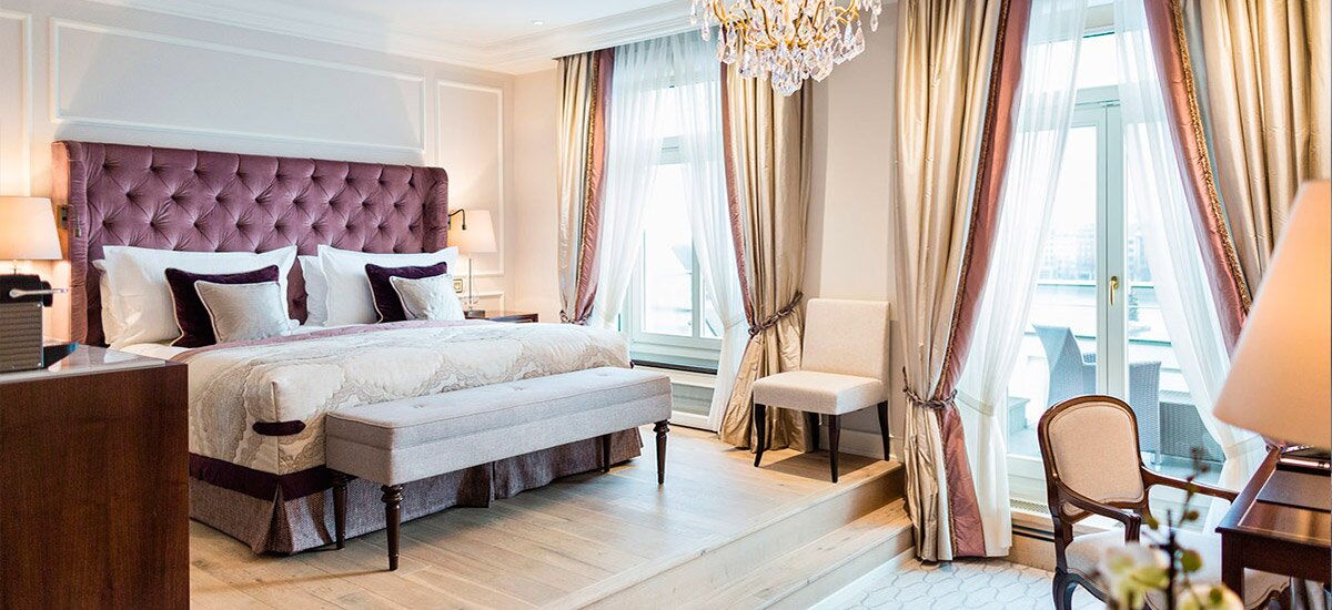 Ein klassisch eingerichtetes Hotelzimmer mit lila Akzenten im Hotel Vier Jahreszeiten in Hamburg