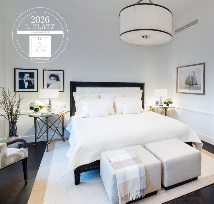 Elegante Ralph Lauren Suite im Hotel Vier Jahreszeiten Hamburg mit hellem Doppelbett und stilvoller Einrichtung
