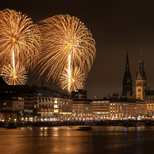 View across the Inner Alster to the buildings and the golden fireworks in the sky