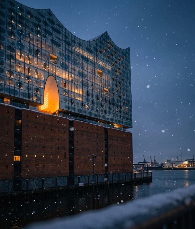 Beleuchtete Elbphilharmonie im Hamburger Hafen bei winterlichem Schneefall