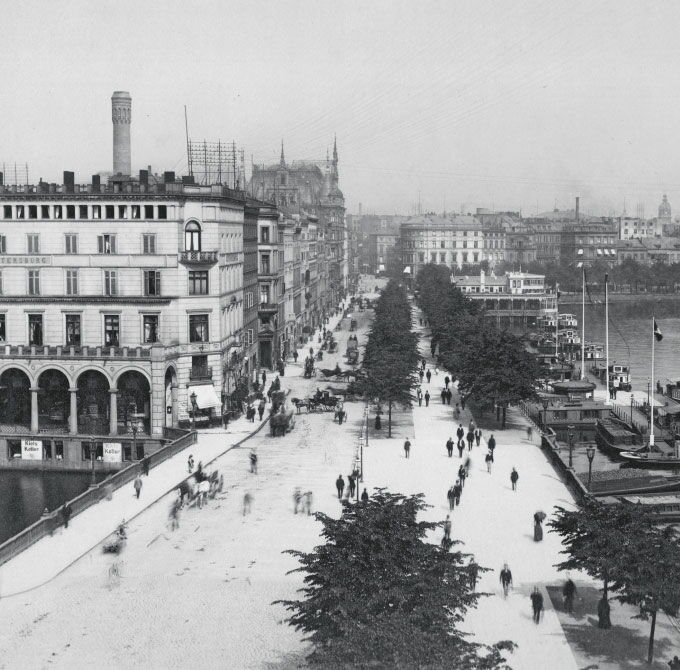 Historische Schwarz-Weiß-Aufnahme des Hamburger Jungfernstiegs an der Binnenalster mit Passanten und Pferdekutschen