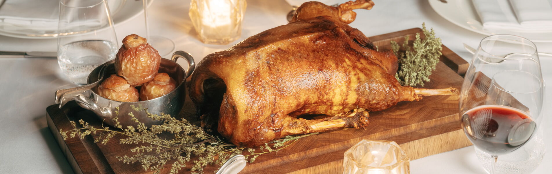 Festlicher Gänsebraten mit klassischen Beilagen auf einer gedeckten Tafel
