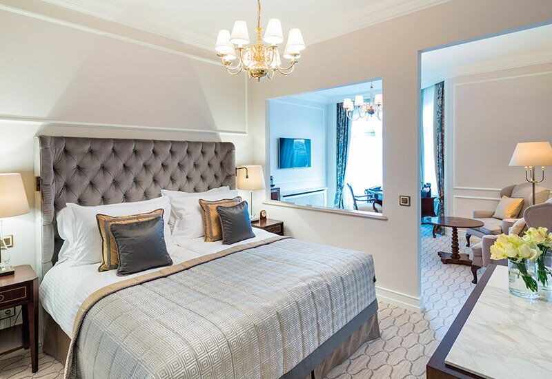 Ein klassisch eingerichtetes Hotelzimmer mit goldenen Akzenten im Hotel Vier Jahreszeiten in Hamburg