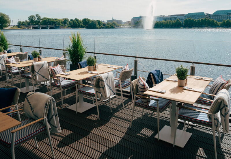 View of the covered seating of the Deck 4 restaurant with a view of the Alster in fine weather