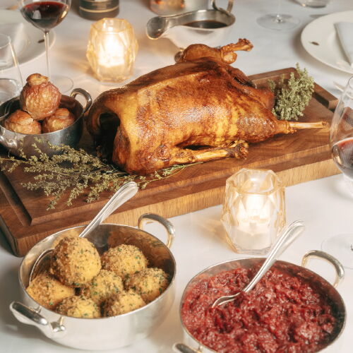 Festlicher Gänsebraten mit klassischen Beilagen auf einer gedeckten Tafel