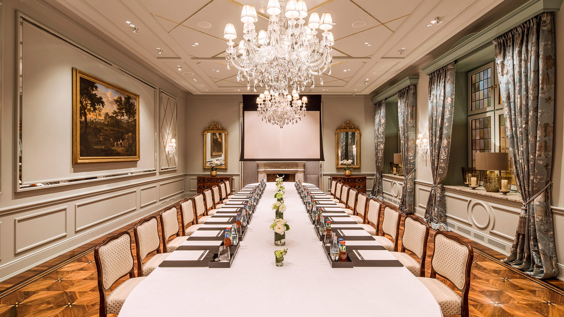 Eine lange gedeckte Tafel im stilvollen Raum mit Kronleuchter im Hotel Vier Jahreszeiten in Hamburg