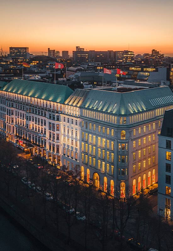 Abendliche Außenansicht des Hotel Vier Jahreszeiten Hamburg an der Binnenalster mit beleuchteter Fassade.