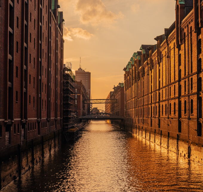 Historische Speicherstadt in Hamburg bei Sonnenuntergang mit Fleeten und roter Backsteinarchitektur.