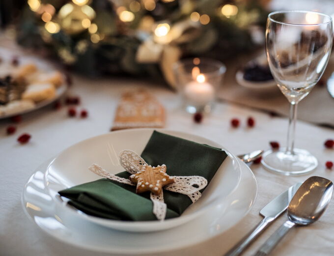 Festively set Christmas table with a green napkin and star-shaped biscuit
