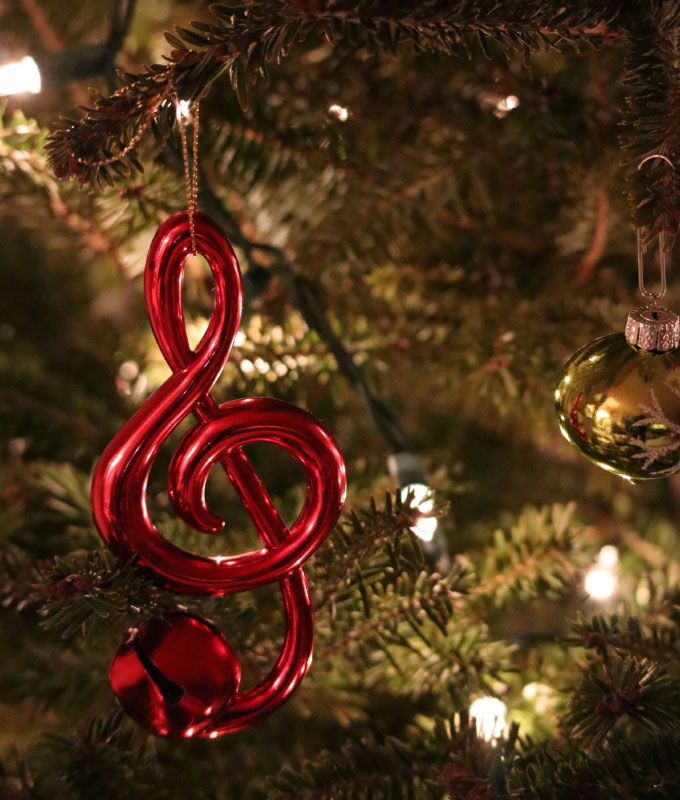 Festive Christmas tree ornament with a red treble clef.