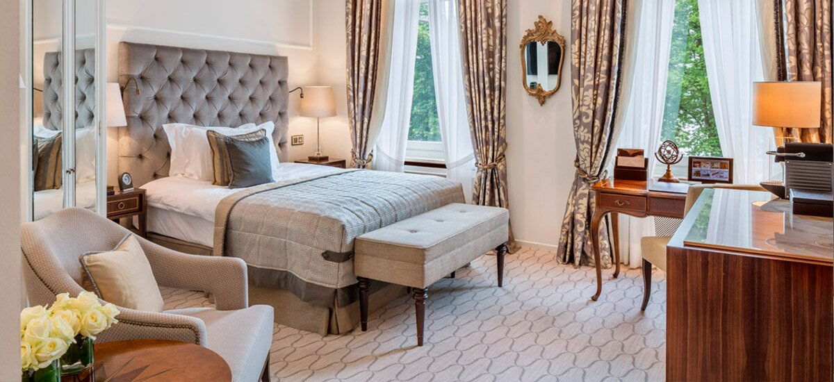 Ein klassisch eingerichtetes Hotelzimmer eingerichtet in neutralen Farben im Hotel Vier Jahreszeiten in Hamburg