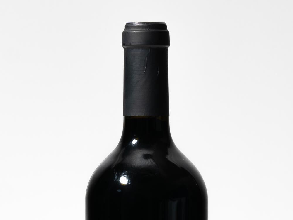 Nahaufnahme des Flaschenhalses des HVJ Rotwein Jahreszeiten Cuvée Schneider (0,75 l) in einer schwarzen Flasche