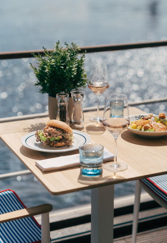 A table set at the Deck 4 restaurant directly on the Alster, shimmering in the sunlight