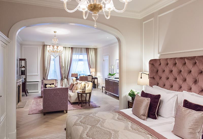 Das rosa eingerichtete Schlafzimmer einer Deluxe Suite zum Innenhof im Hotel Vier Jahreszeiten in Hamburg