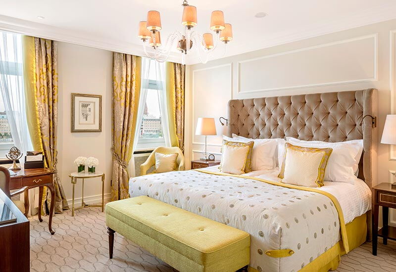 Der gelb und gold eingerichtete Schlafbereich im Doppelzimmer Alster Deluxe im Hotel Vier Jahreszeiten in Hamburg