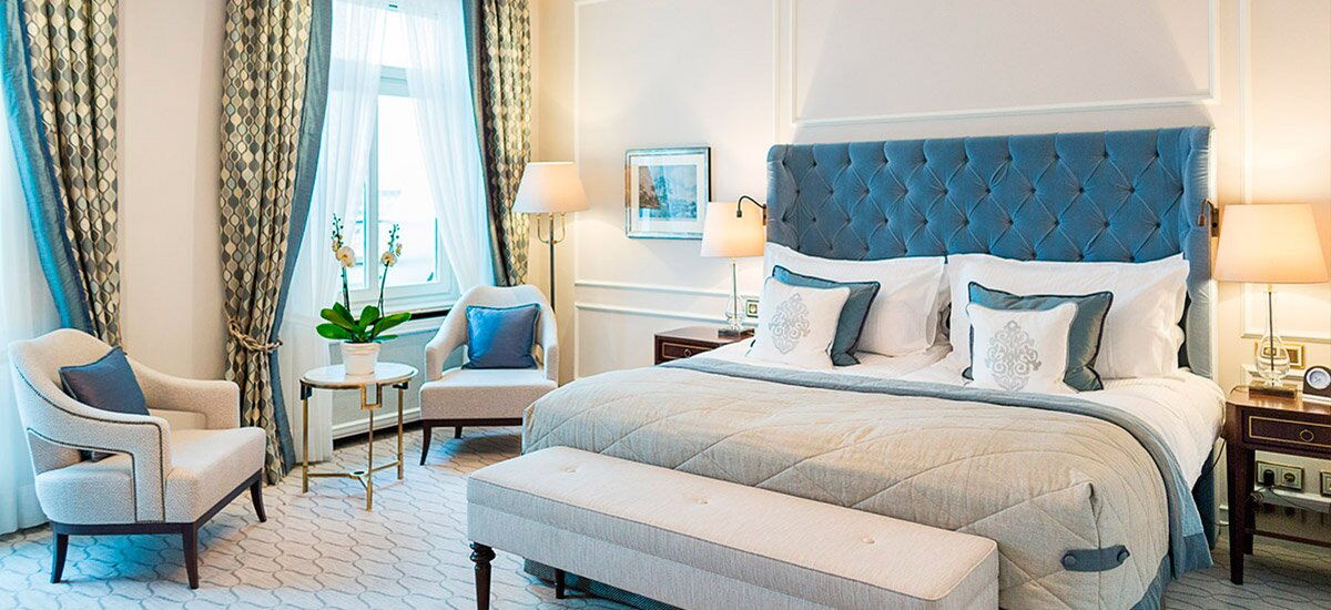 Ein klassisch eingerichtetes Hotelzimmer mit türkisen Akzenten im Hotel Vier Jahreszeiten in Hamburg