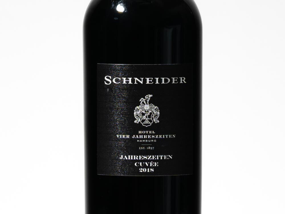 Nahaufnahme des Etiketts des HVJ Rotwein Jahreszeiten Cuvée Schneider (0,75 l) in einer schwarzen Flasche