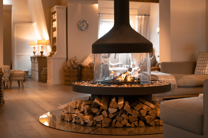 Spa & fitness room with cosy sofa corner and a fireplace in the middle