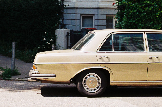Luxurious gold Mercedes-Benz photographed at an intersection