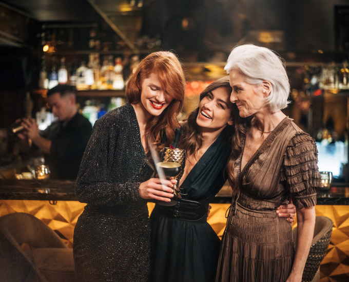 Three women celebrating at the Nikkei Nine Bar with drinks in hand