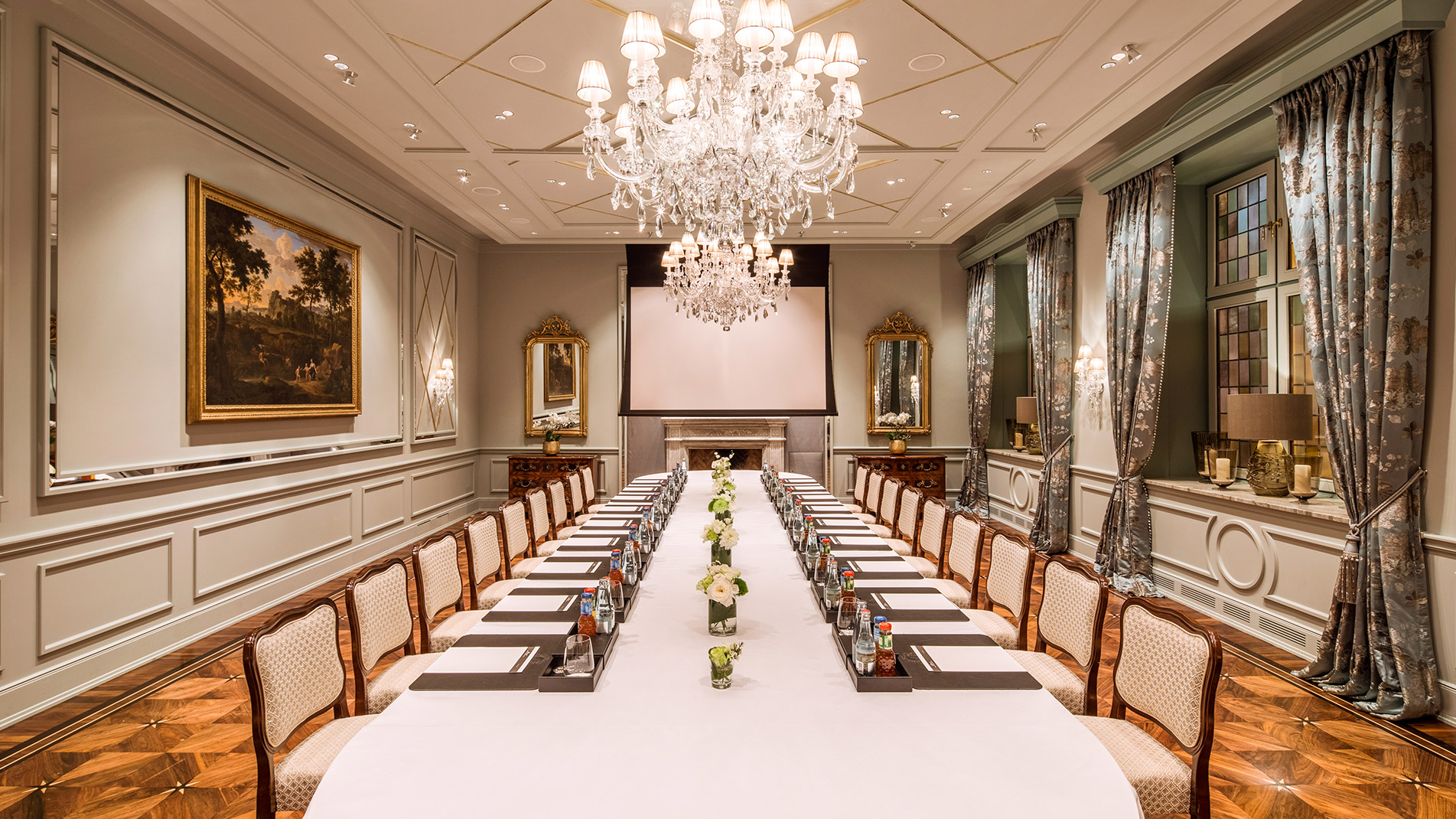 Eine lange gedeckte Tafel im stilvollen Raum mit Kronleuchter im Hotel Vier Jahreszeiten in Hamburg