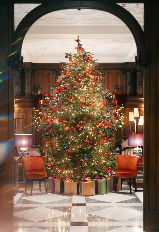 Festively decorated Christmas tree with presents in the lobby of the Hotel Vier Jahreszeiten in Hamburg